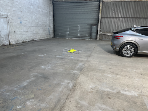 UAV filming on location for Ebbon Intelligence industrial unit with a car and a yellow stuffed toy on the floor